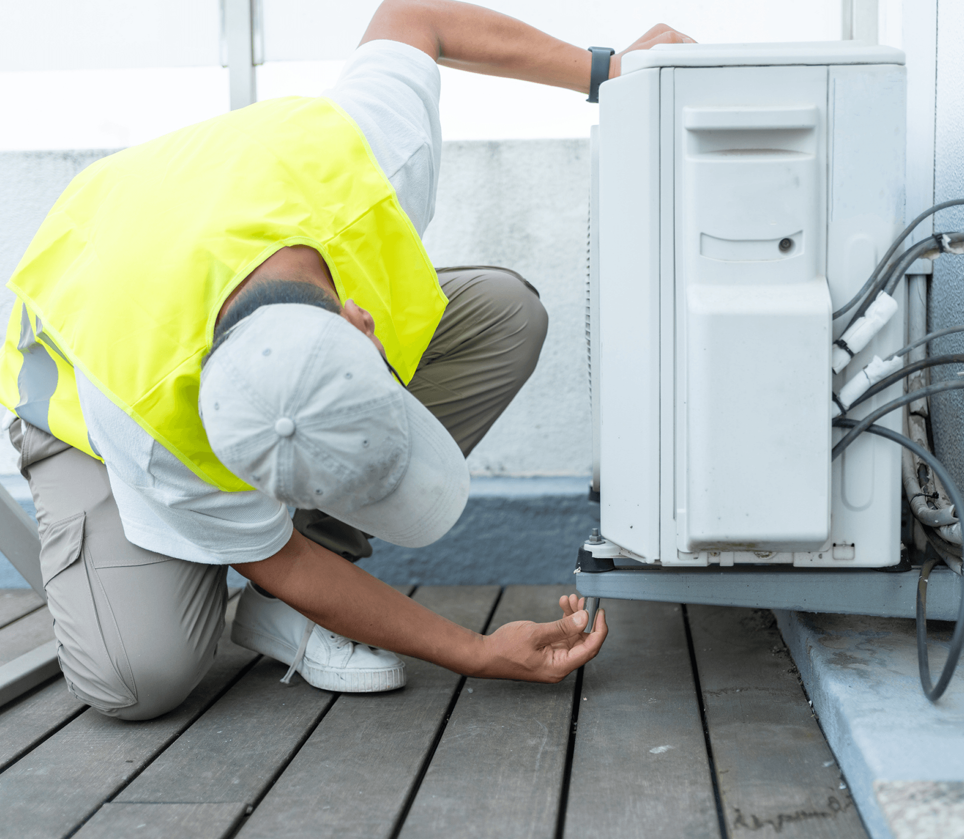 Worker adjusting air conditioner on rooftop