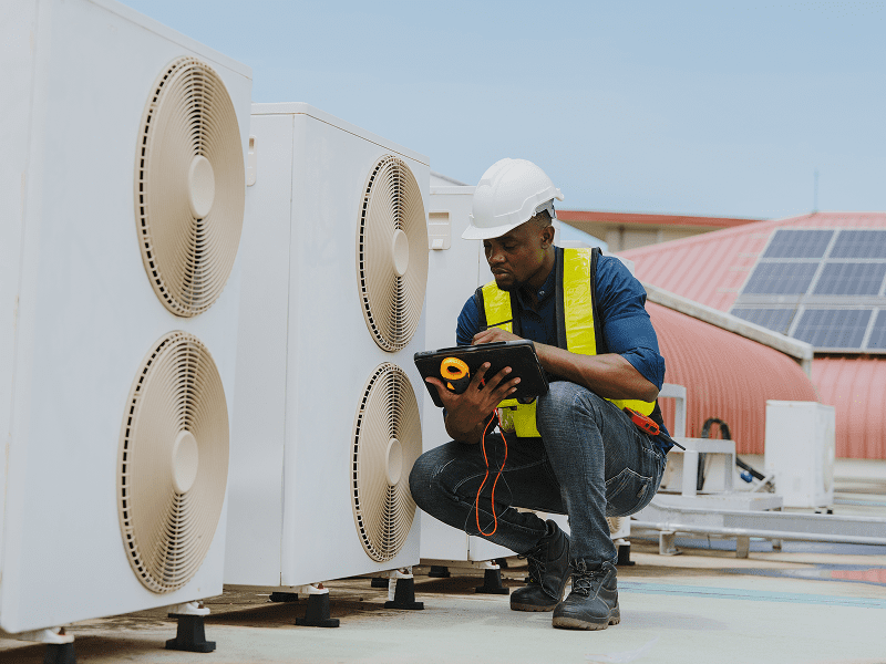 Technician inspecting rooftop HVAC units