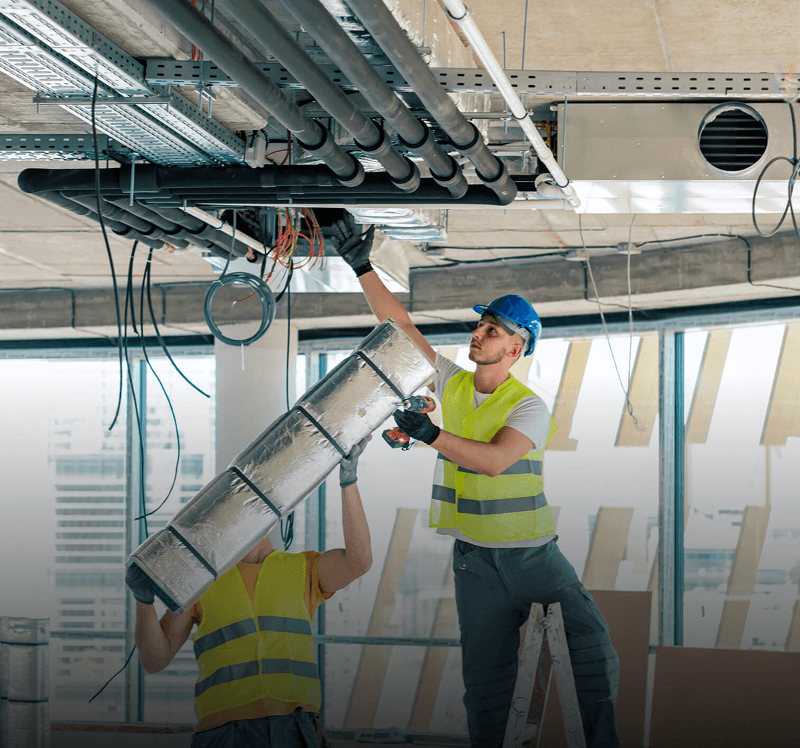 Workers installing ductwork in a building.